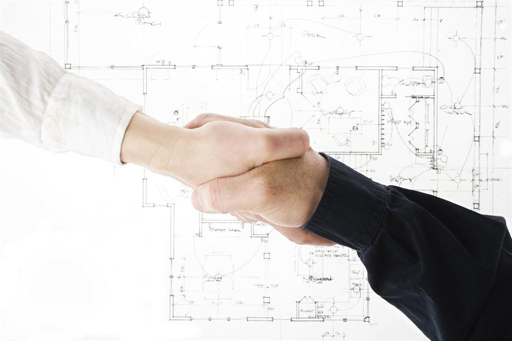 Handshake above building plans